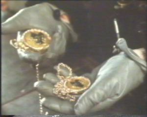 He shows the locket to the Colonel