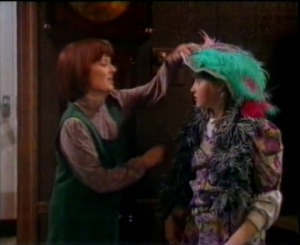 Nia's mum takes off the hat and dress